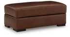 Brown leather upholstered ottoman with rounded top and square block legs