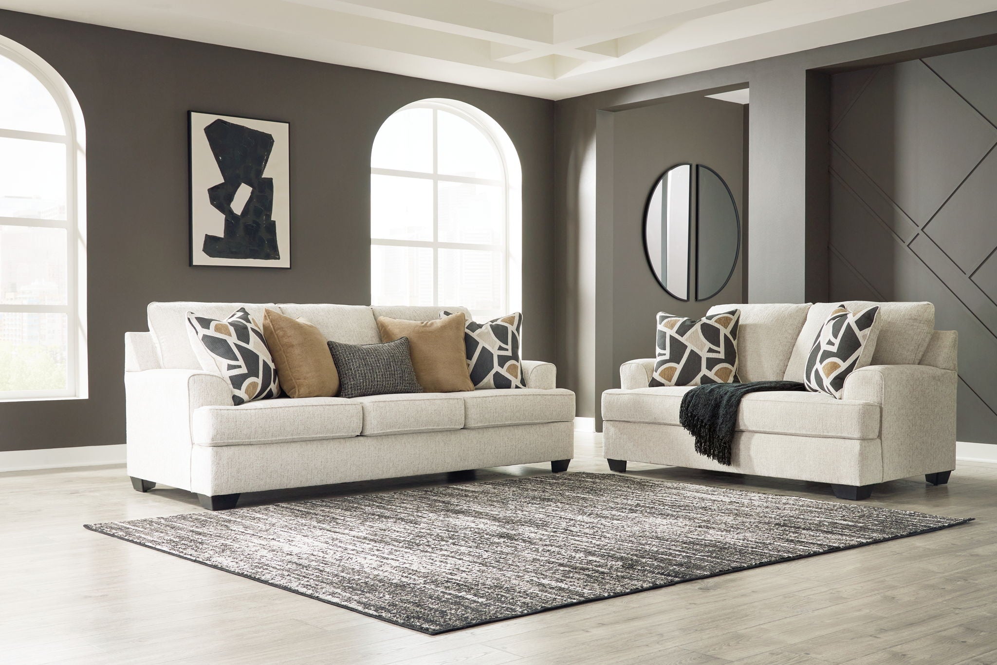 Beige upholstered sofa and chair set with geometric throw pillows