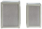 Silver nesting end table with textured panel doors and glass top, side view