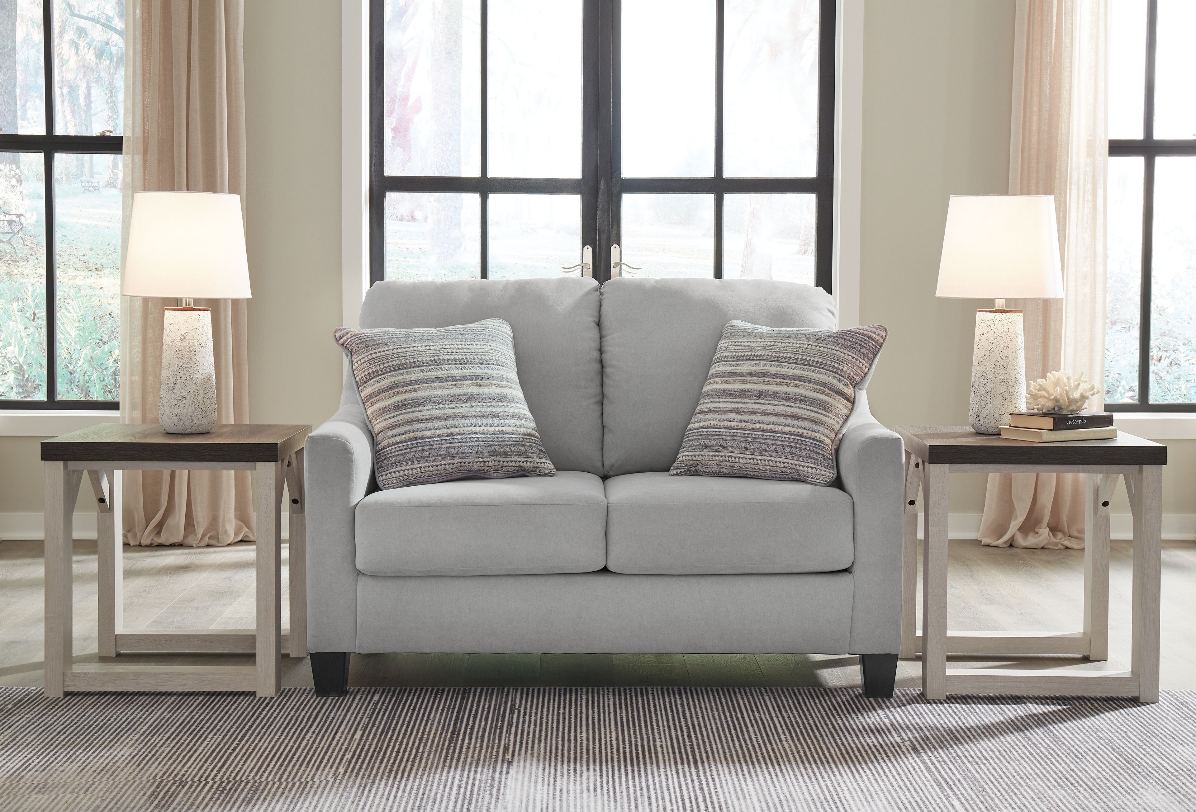 Gray loveseat with four striped throw pillows and two plush seat cushions