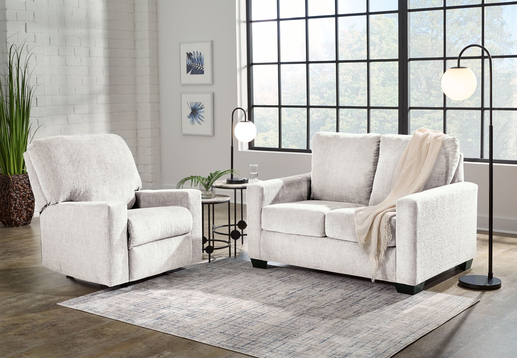 Light fabric sofa with matching armchair, throw draped on right arm