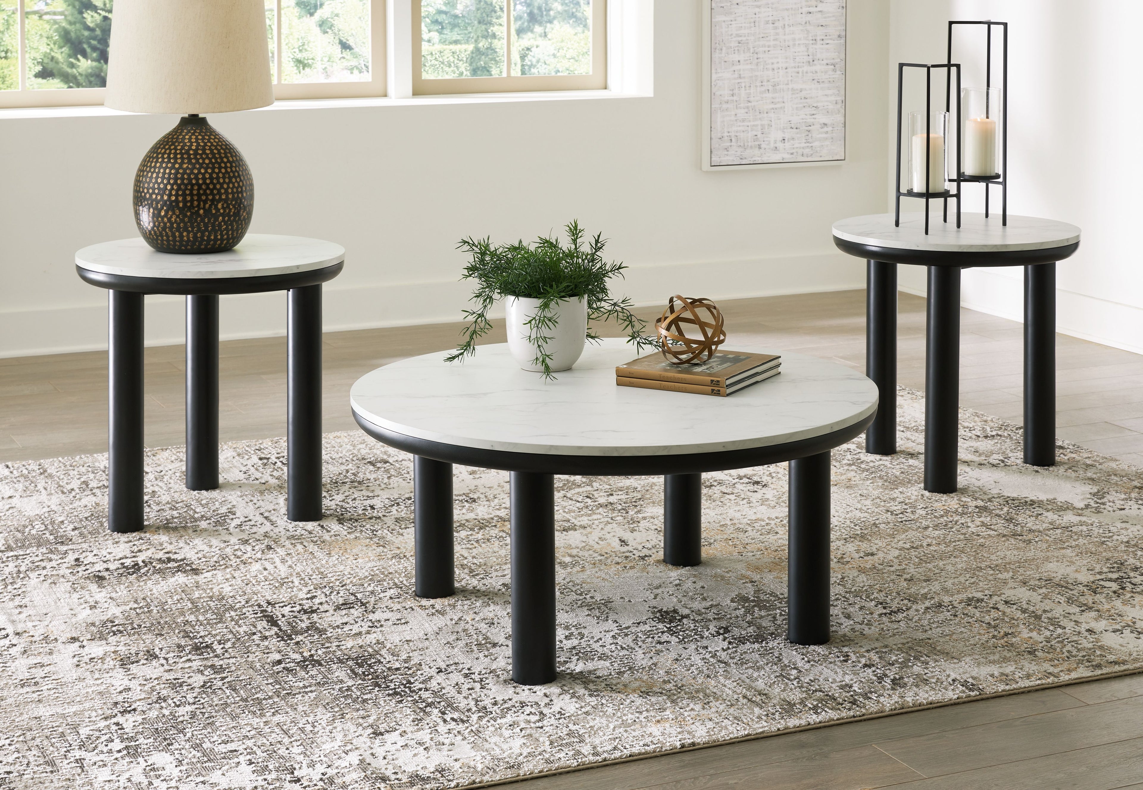 Set of 3 round side tables with white tabletops and black legs in a room
