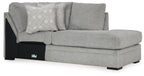 Cement gray corner chaise sofa with patterned throw pillows and black accent base