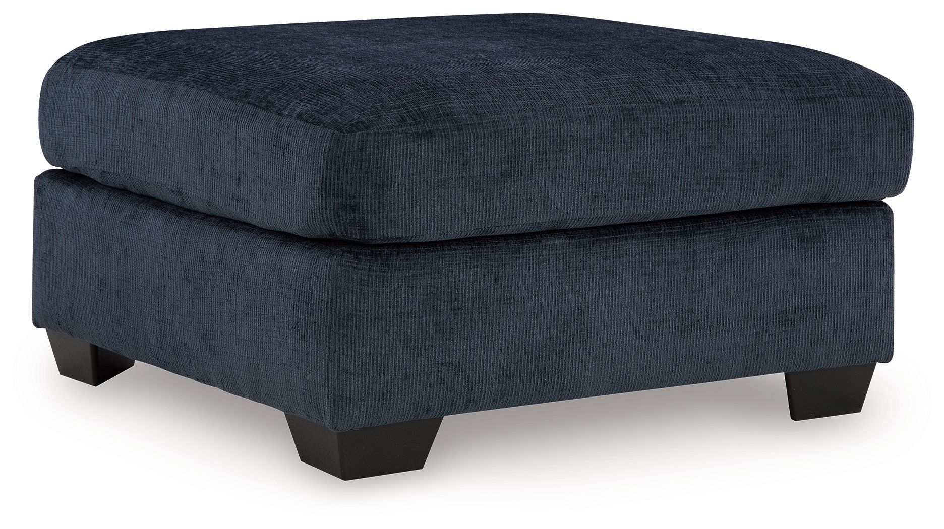 Navy upholstered ottoman with round-corner lid and dark block legs.