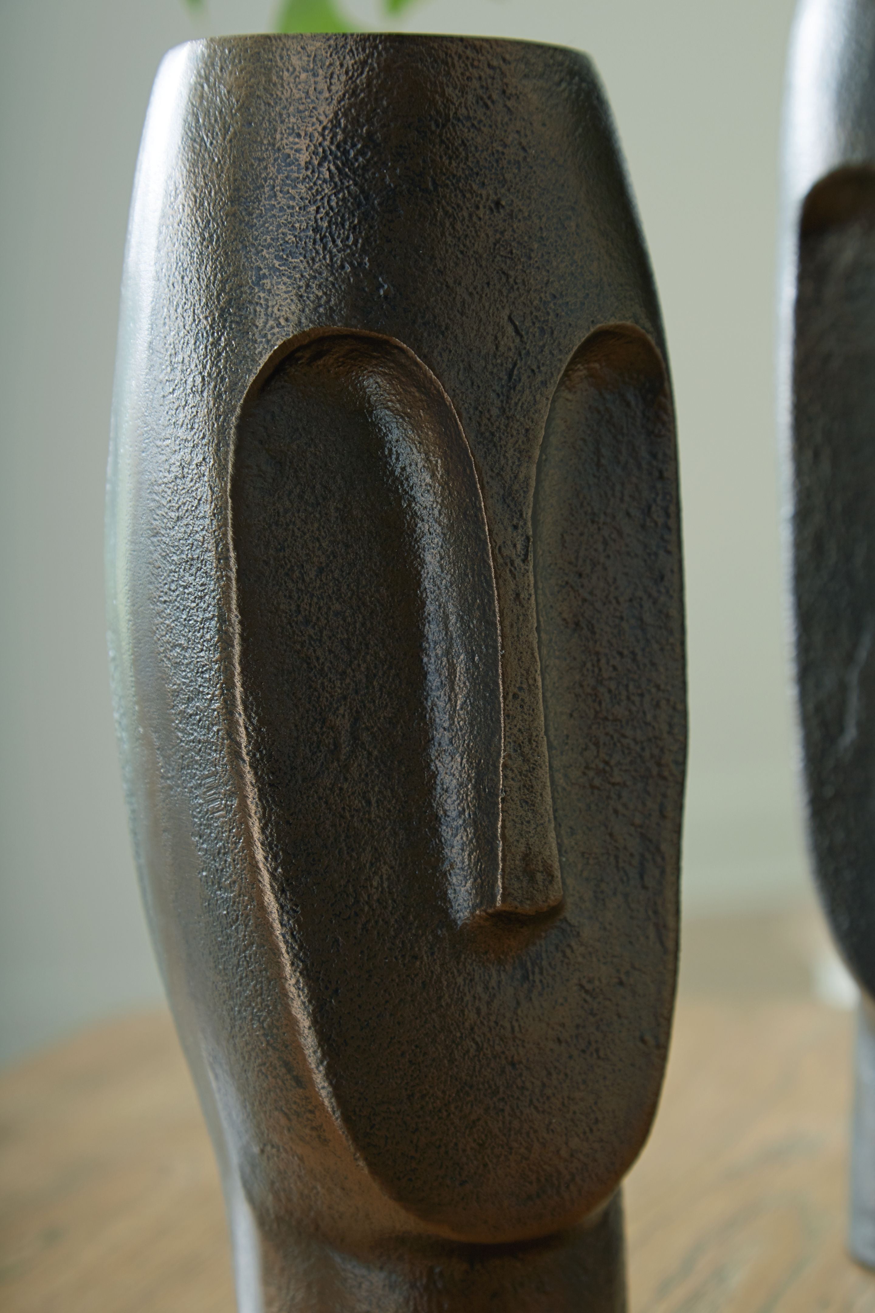 Tall bronze textured vase with arched cutout, close side view