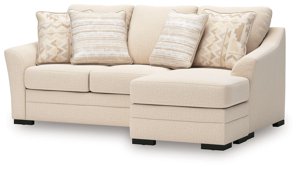 Queen sofa chaise sleeper with light beige chaise and armrests, patterned and striped pillows