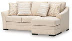 Queen sofa chaise sleeper with light beige chaise and armrests, patterned and striped pillows