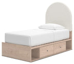 Beige upholstered panel bed with arched headboard, white mattress, and two front drawers in wood base