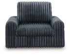 Gunmetal corduroy power gliding chaise with tufted seat, rounded armrests, tall back.