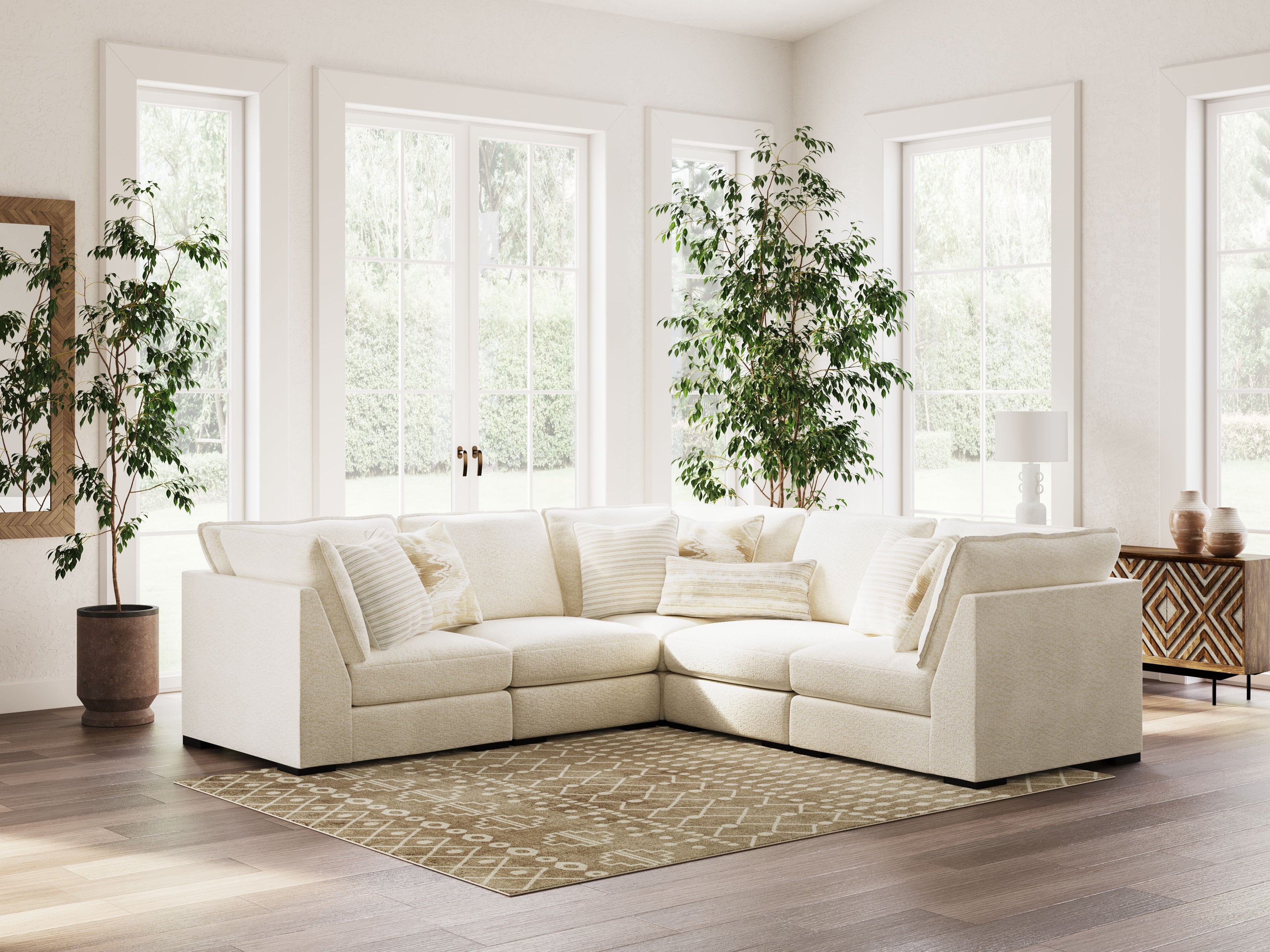 Vanilla sectional sofa with chaise-style corner, layered throw pillows, and upholstered arms