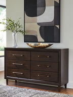 Dark brown dresser with six drawers and brass bar pulls, angled view