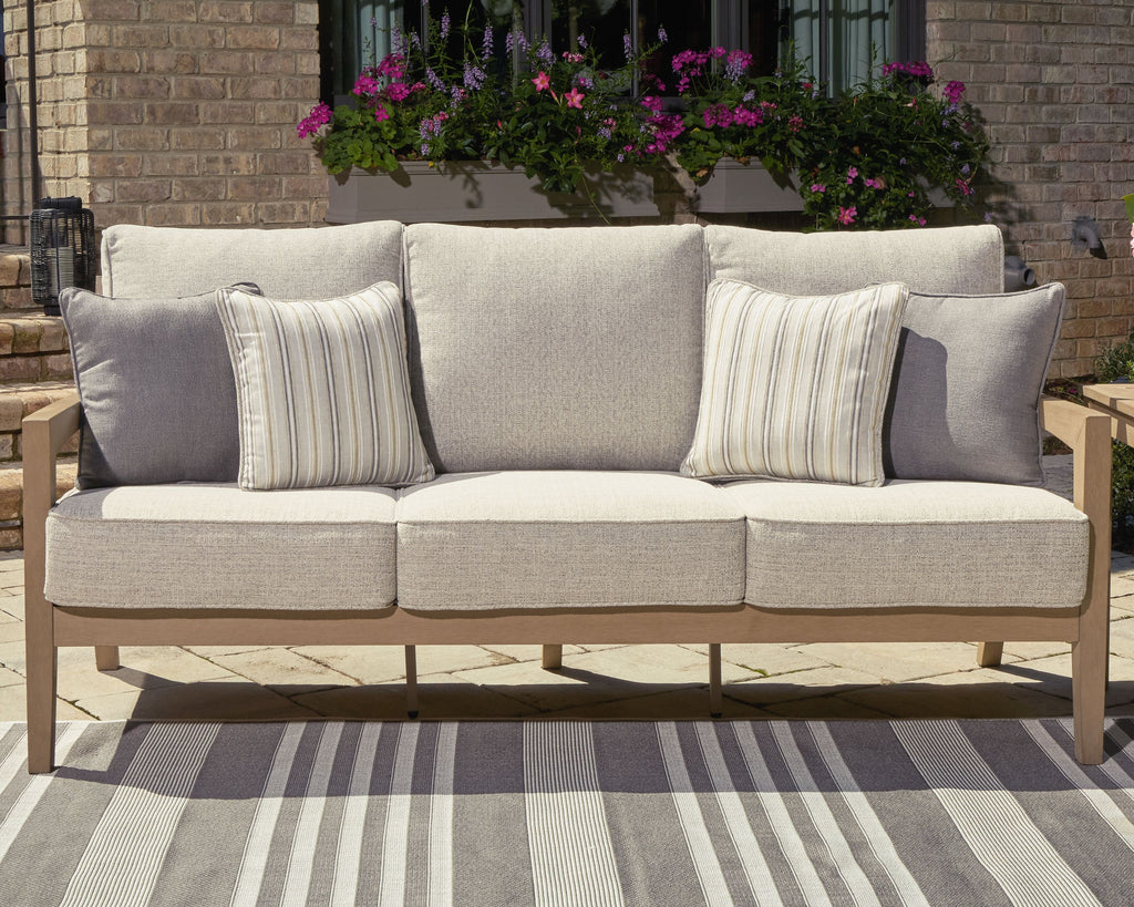 Light beige sofa with four cushions, two striped pillows, and dark gray accent cushions