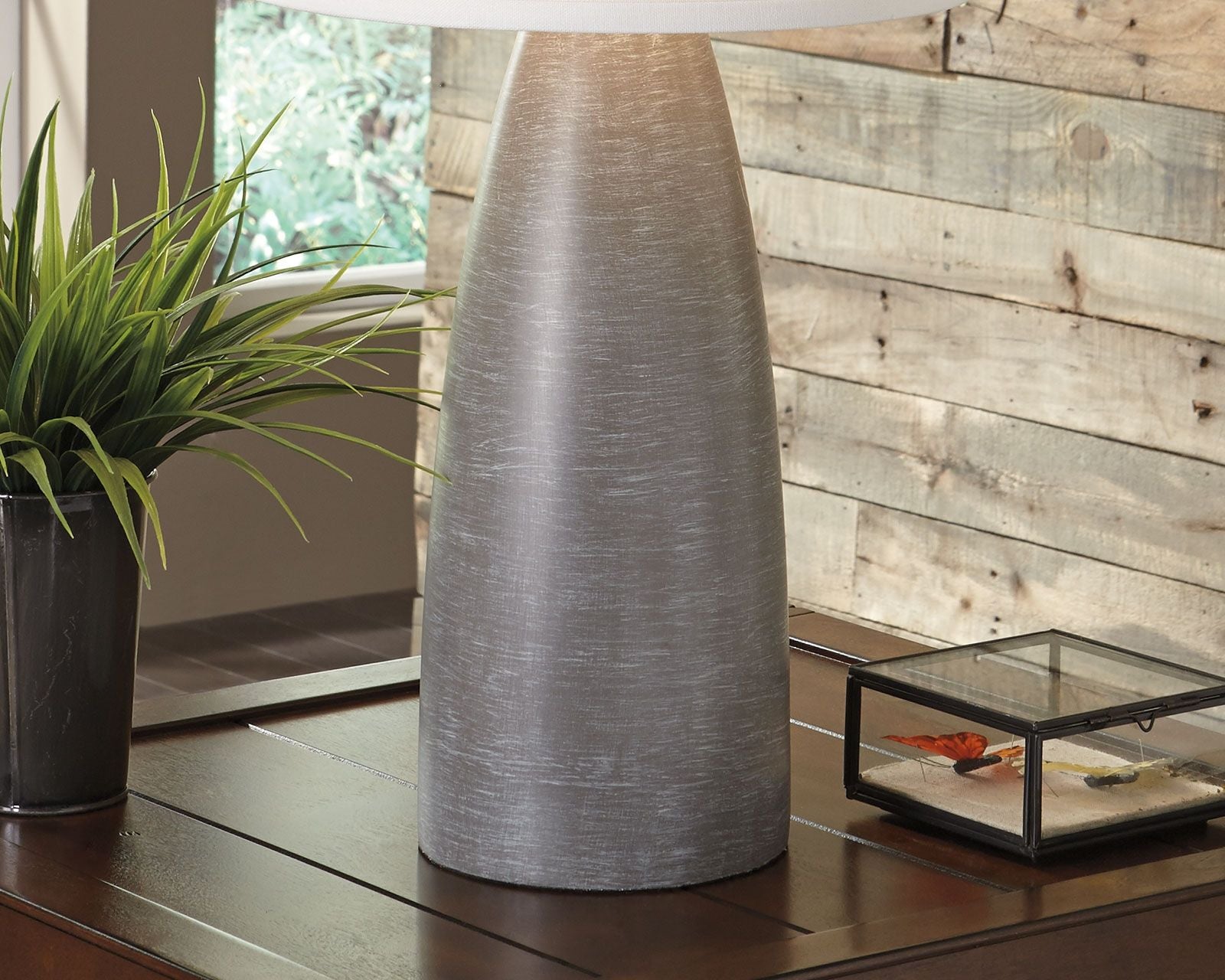 Table lamp shown from the side with white shade and dark gray textured base