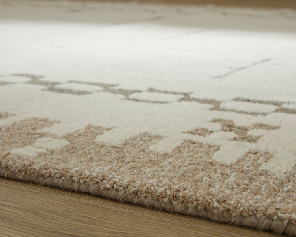 Flatweave area rug corner with light tan pile and beige abstract dot pattern