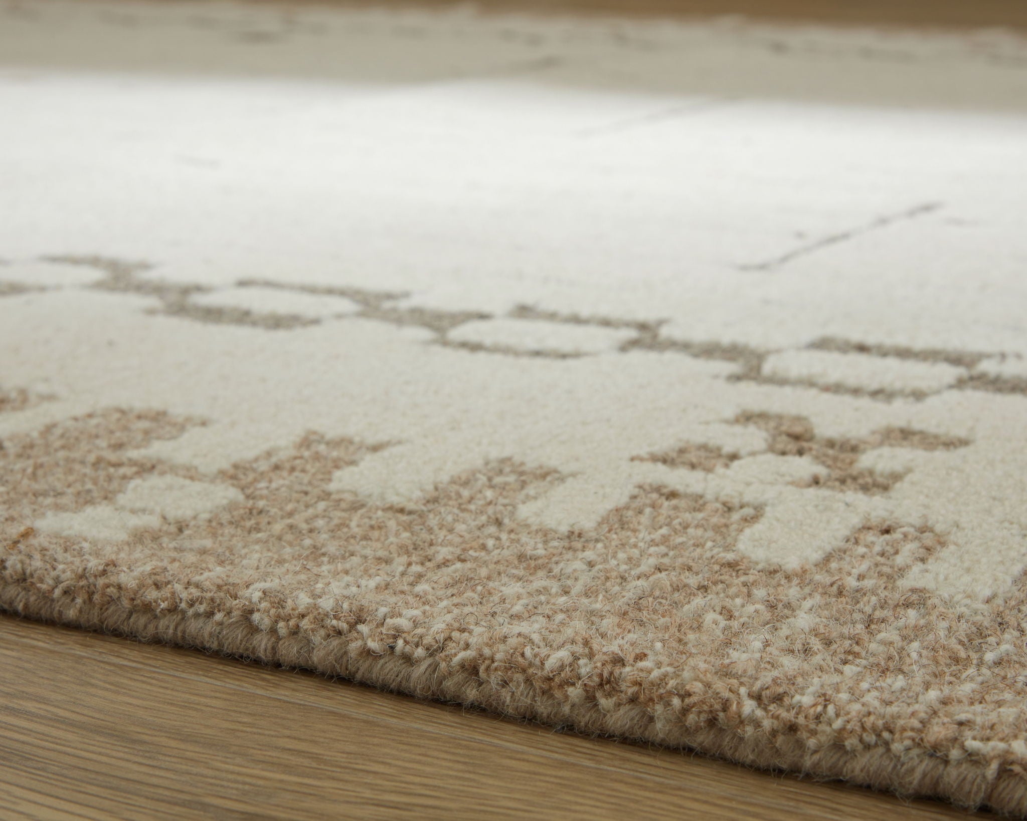 Flatweave area rug corner with light tan pile and beige abstract dot pattern