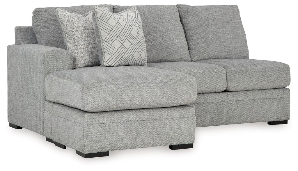 Gray sofa chaise with wide chaise seat, three back cushions, and patterned accent pillow