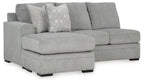 Gray sofa chaise with wide chaise seat, three back cushions, and patterned accent pillow