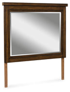 Medium brown wooden bedroom mirror with rectangular frame and beveled glass