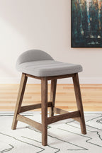Upholstered barstool with light gray fabric seat and curved back, wood legs.