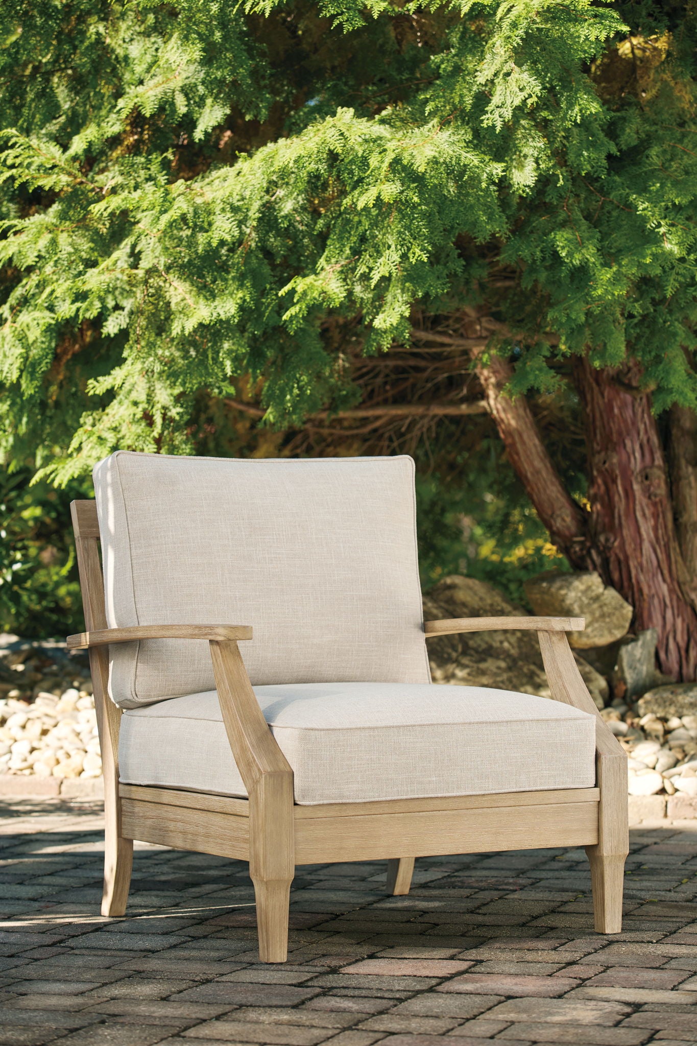 Beige lounge chair with wide arms, square back, and solid seat cushion