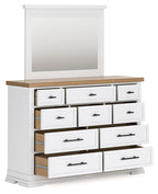 White dresser with mirror, light wood top, multiple drawers with black bar pulls