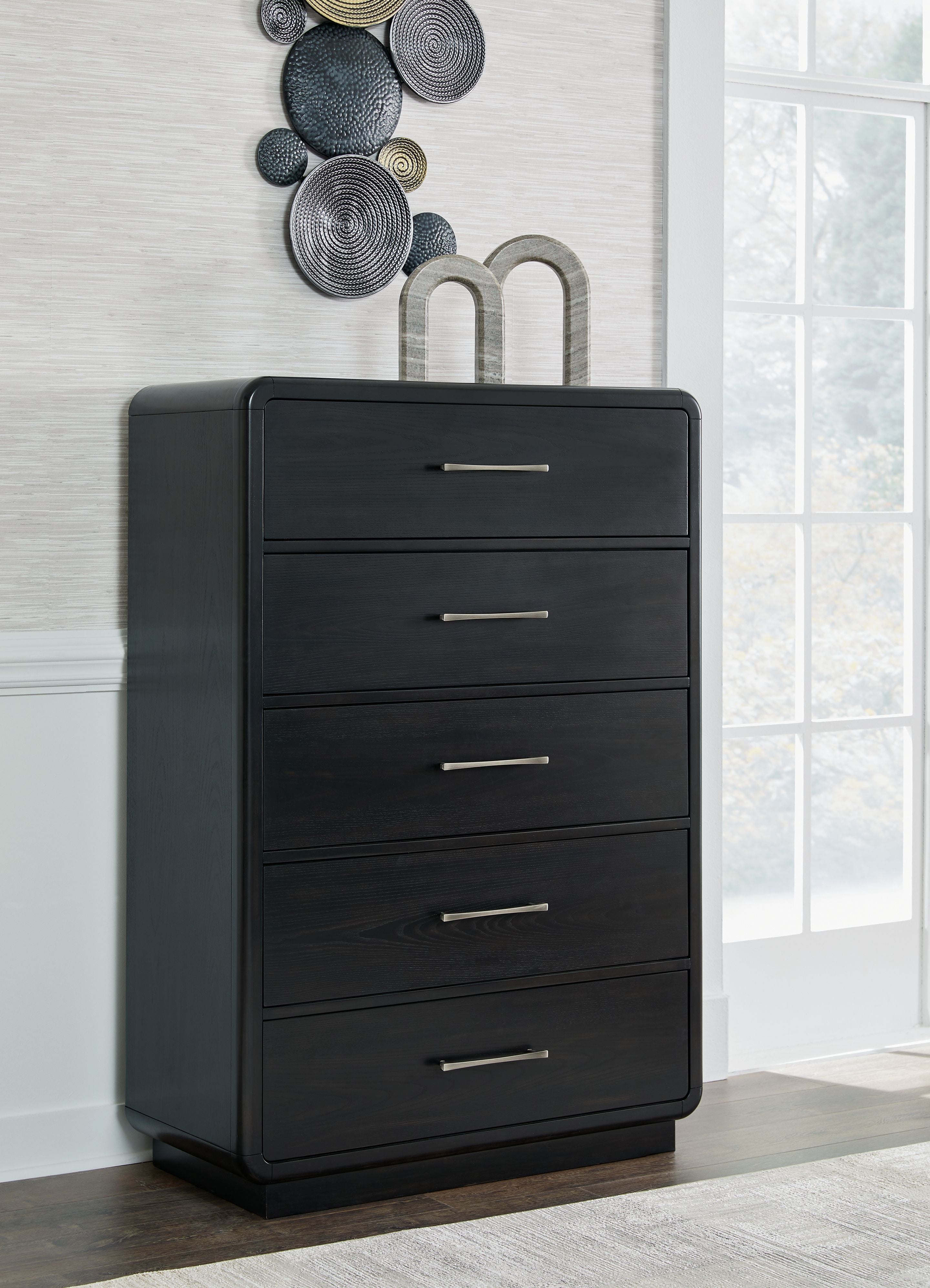 Black five-drawer chest with metal bar handles, shown freestanding.