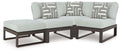 Outdoor sectional corner chair with light gray cushions and geometric accent pillows