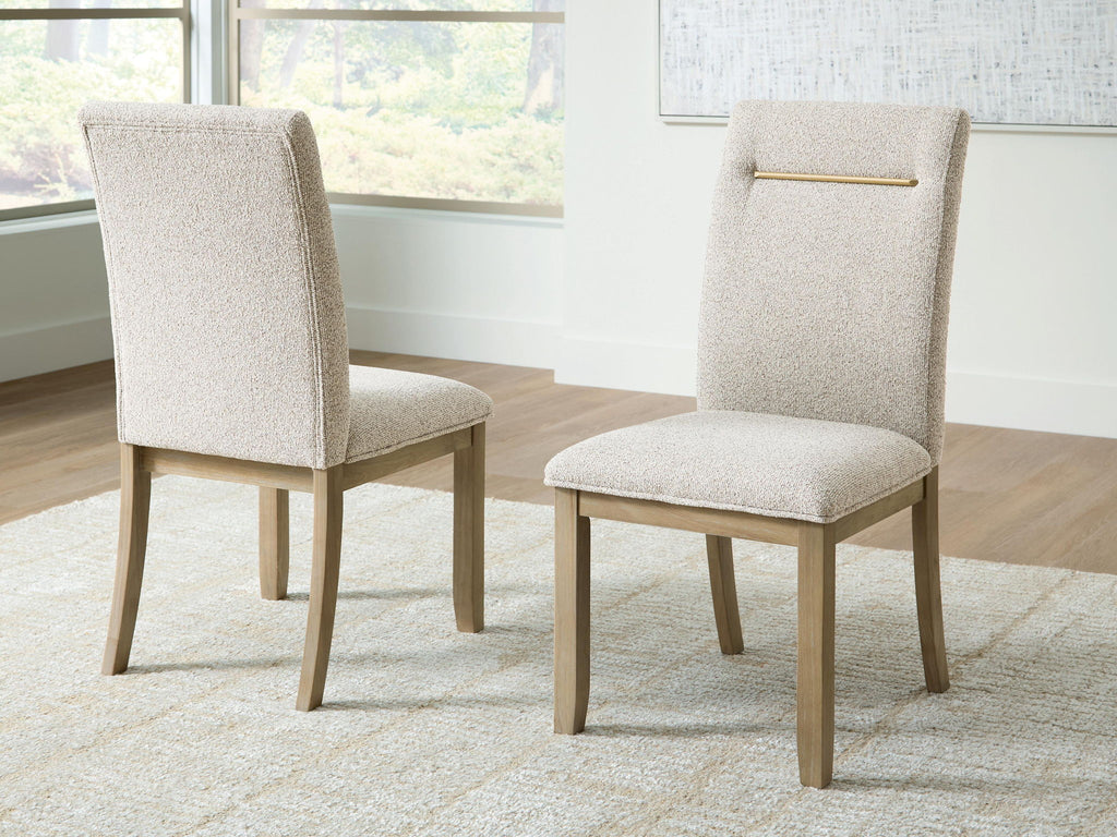 Light beige upholstered dining side chair, angled view, gold bar across the back