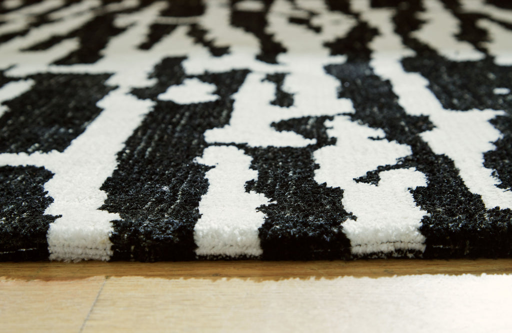 Black-and-white abstract rug surface with short pile and high-contrast pattern