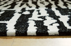 Black-and-white abstract rug surface with short pile and high-contrast pattern