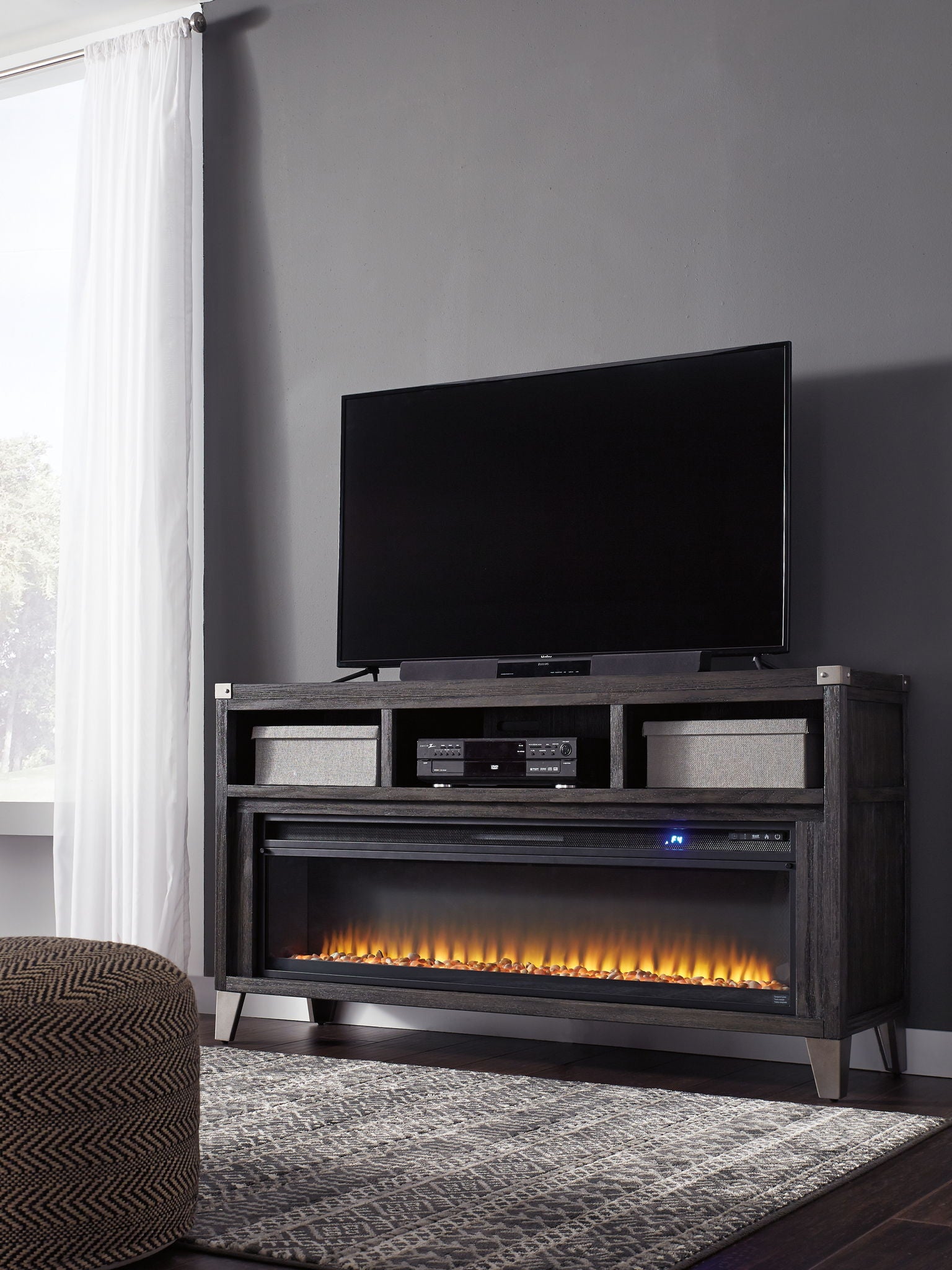 Gray TV media console with fireplace insert and two side cabinet shelves