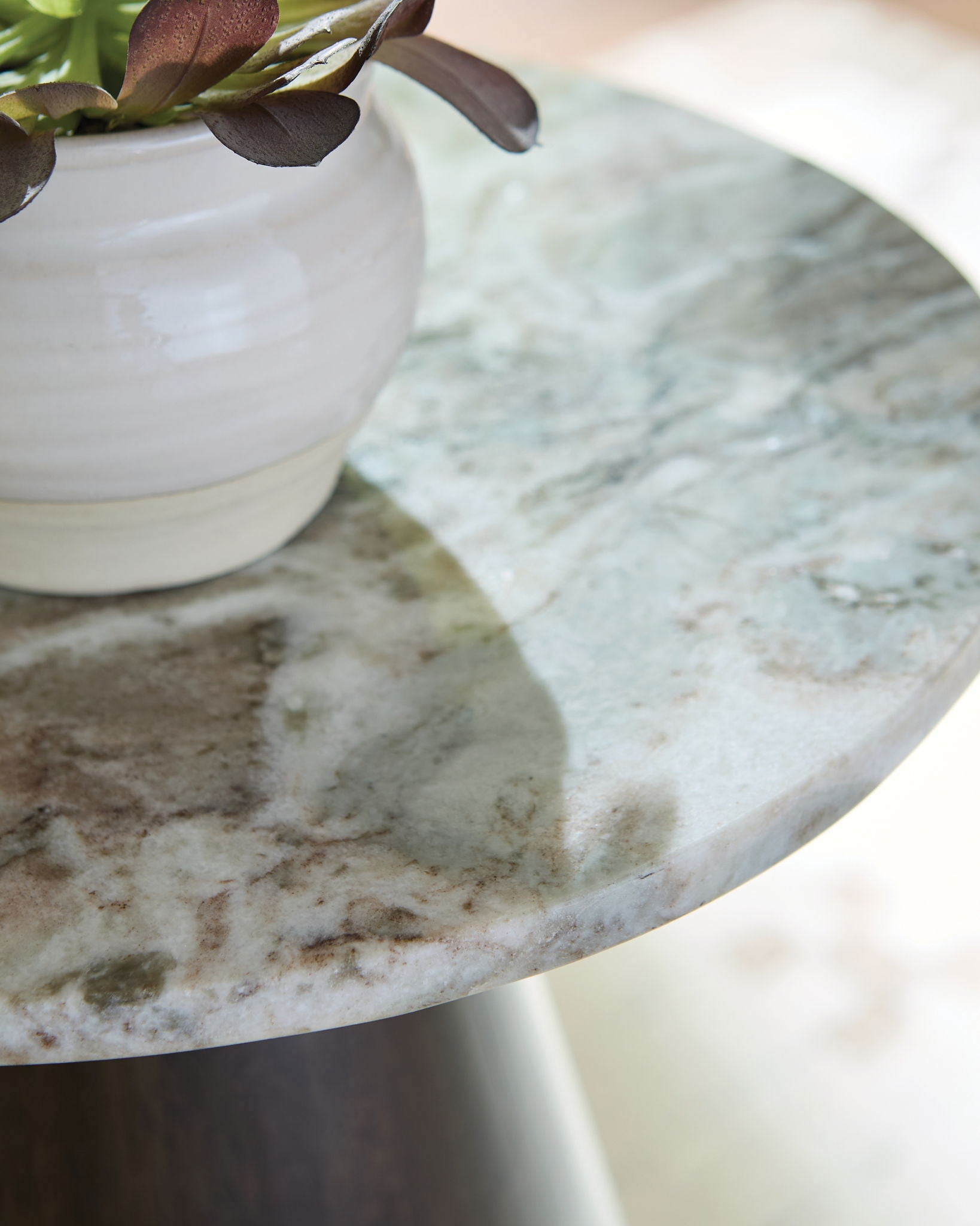 Round accent table top with gray, white, and brown stone-like surface texture