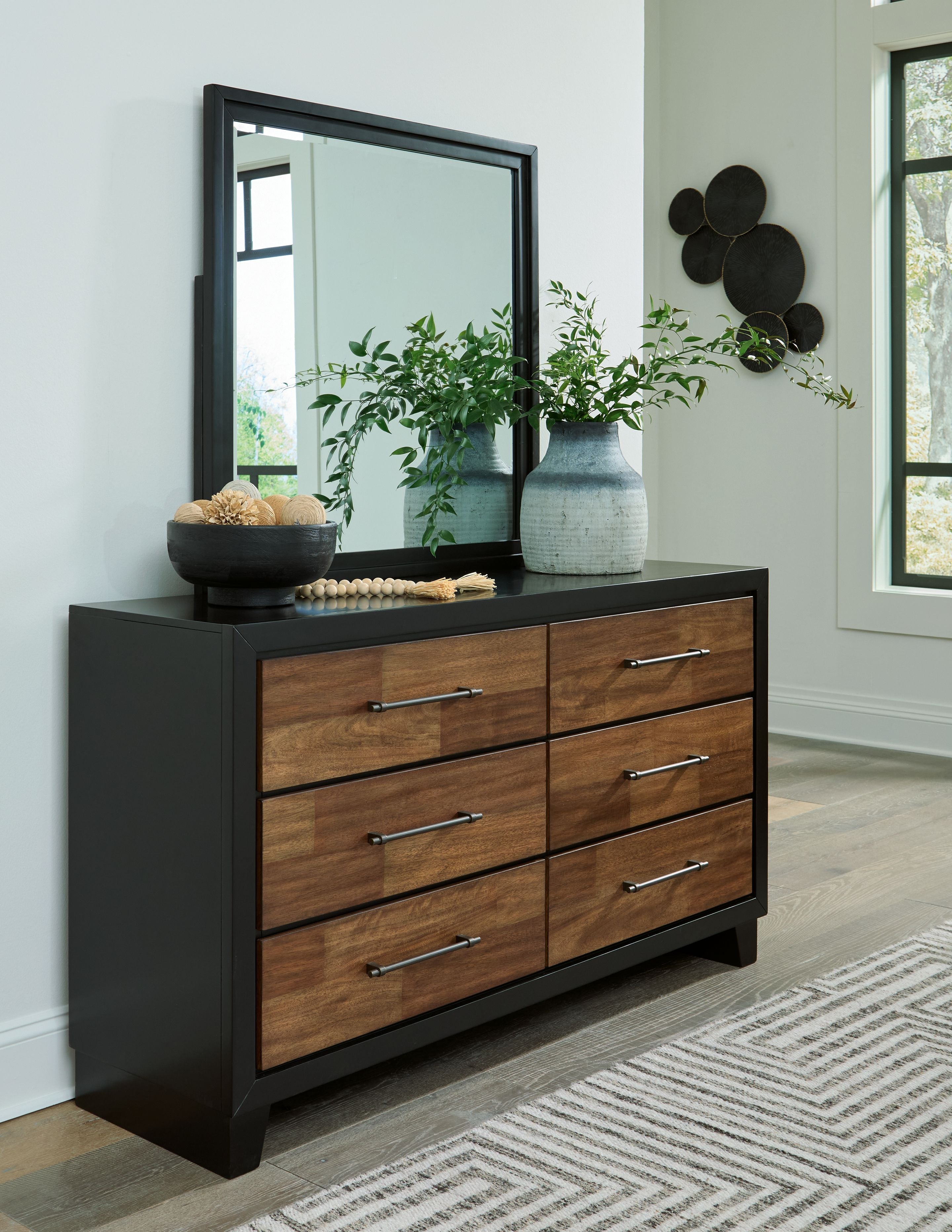 Brown wood dresser with black base, mirror and six drawers, silver bar pulls