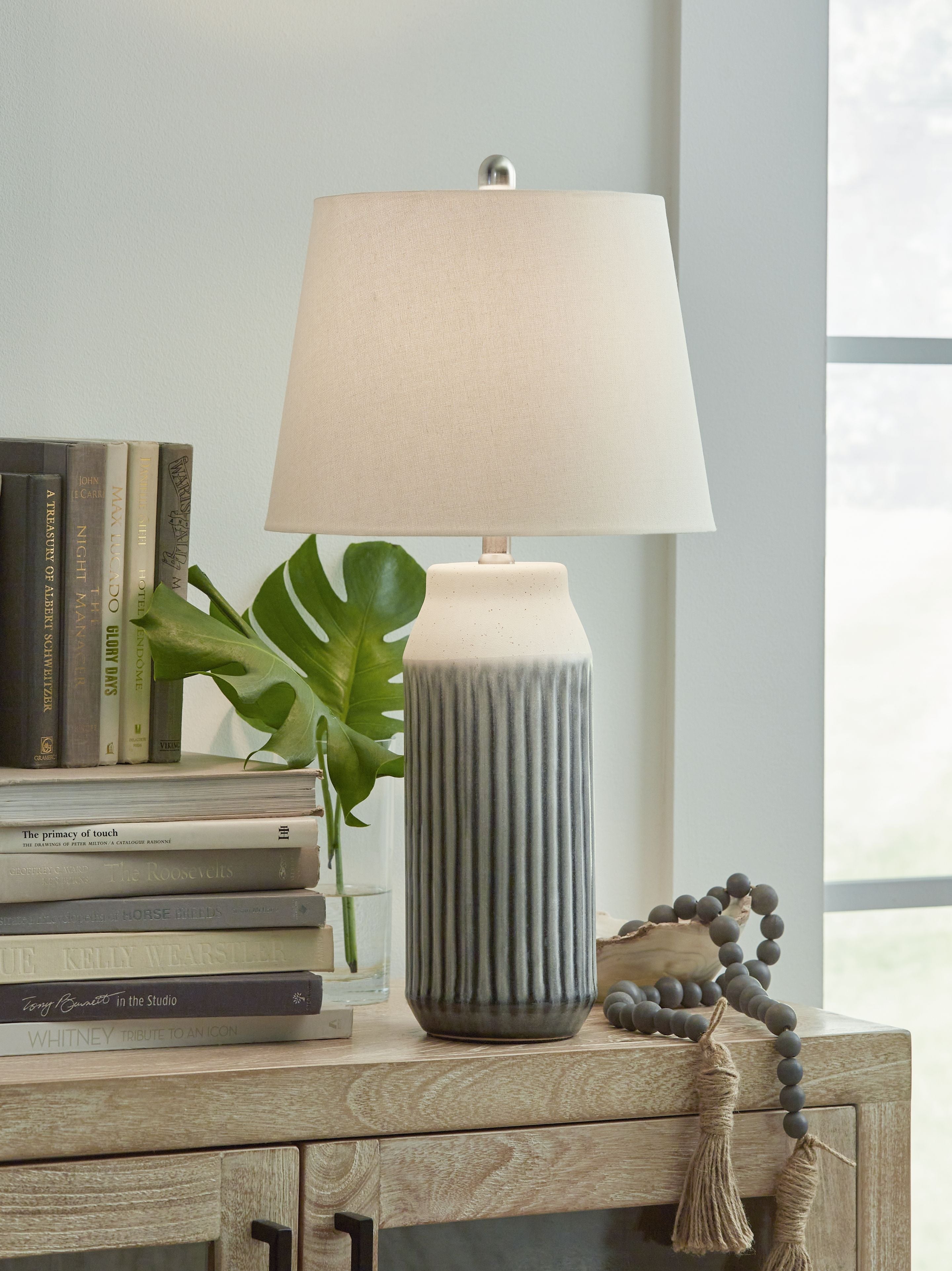 Ceramic table lamp with ribbed blue ceramic base and beige fabric shade