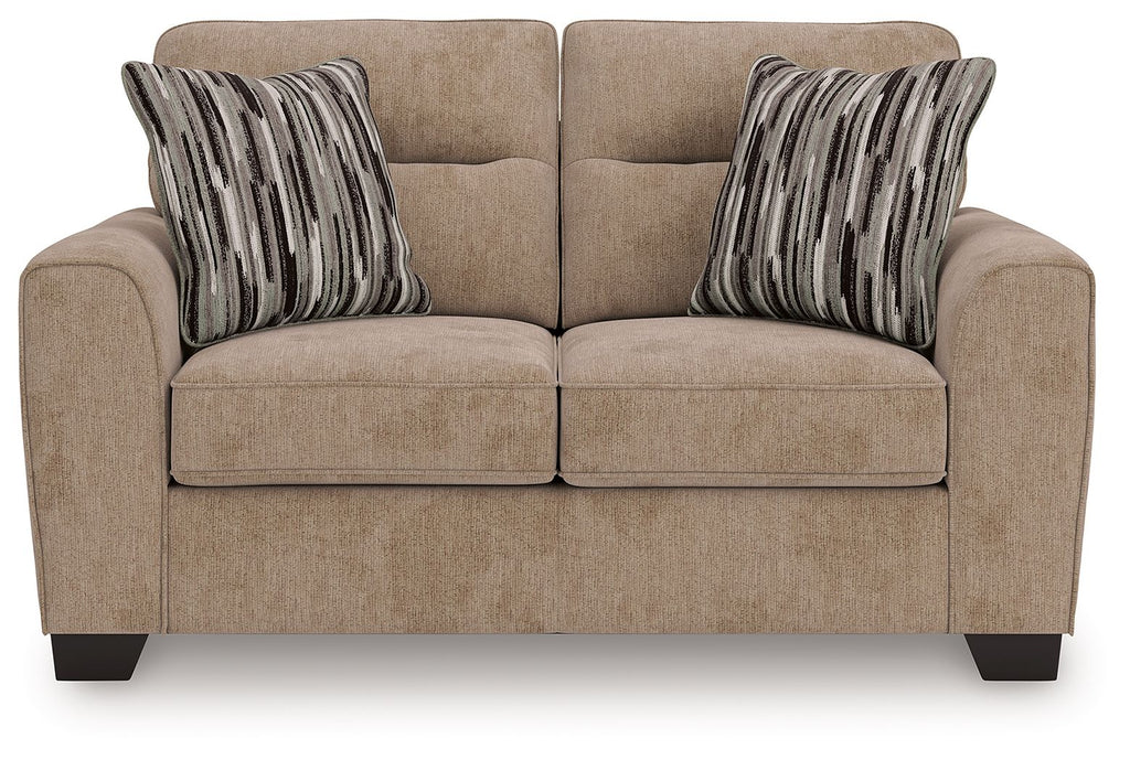 Light brown upholstered loveseat with two seat cushions and striped throw pillows