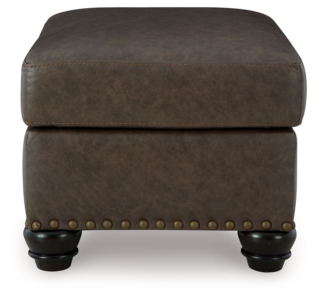 Dark brown tuftless ottoman with nailhead band and short turned legs