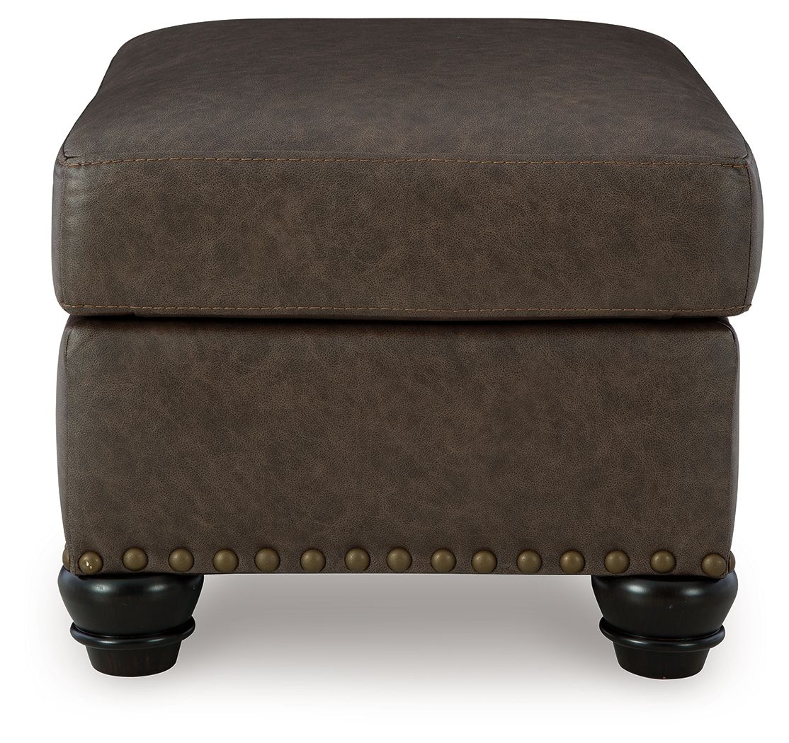Dark brown tuftless ottoman with nailhead band and short turned legs