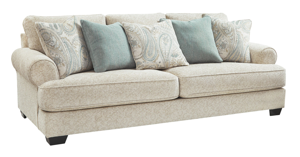 Beige fabric sofa with paisley and blue throw pillows, rolled arms and dark feet