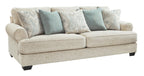 Beige fabric sofa with paisley and blue throw pillows, rolled arms and dark feet