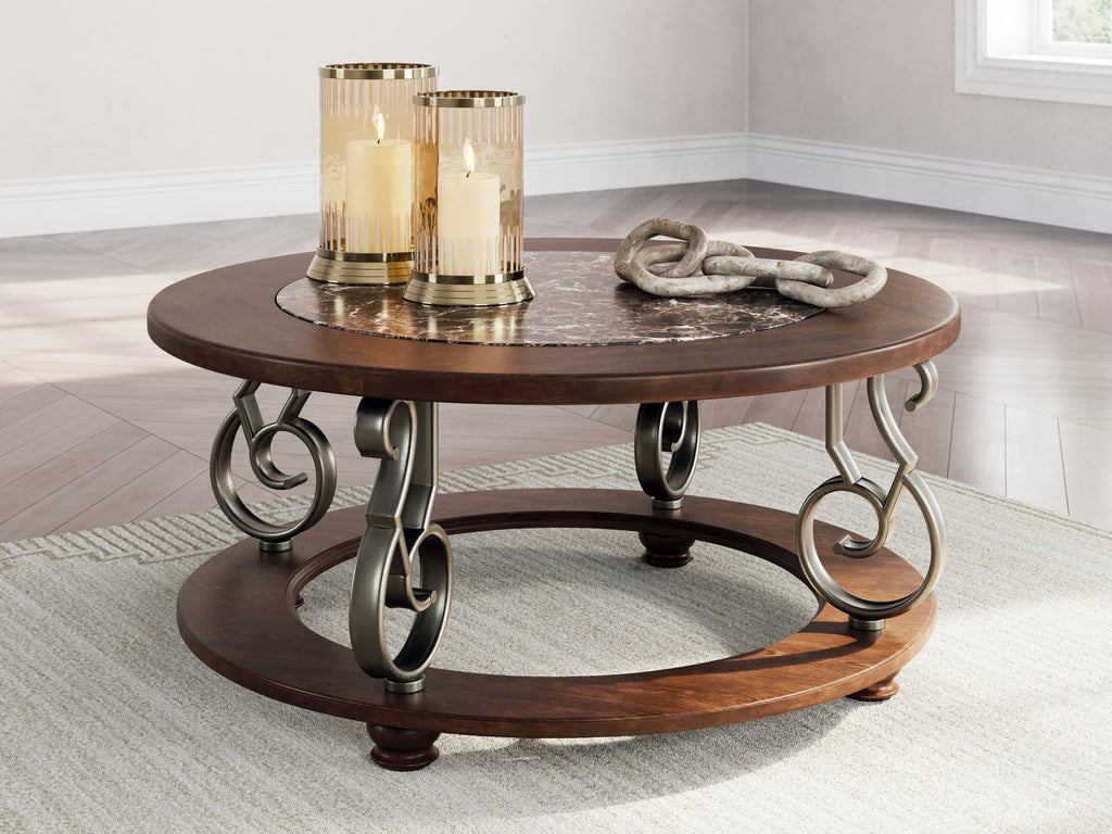 Dark brown round cocktail table with marble top and lower shelf, wrought-iron scroll base