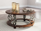 Dark brown round cocktail table with marble top and lower shelf, wrought-iron scroll base