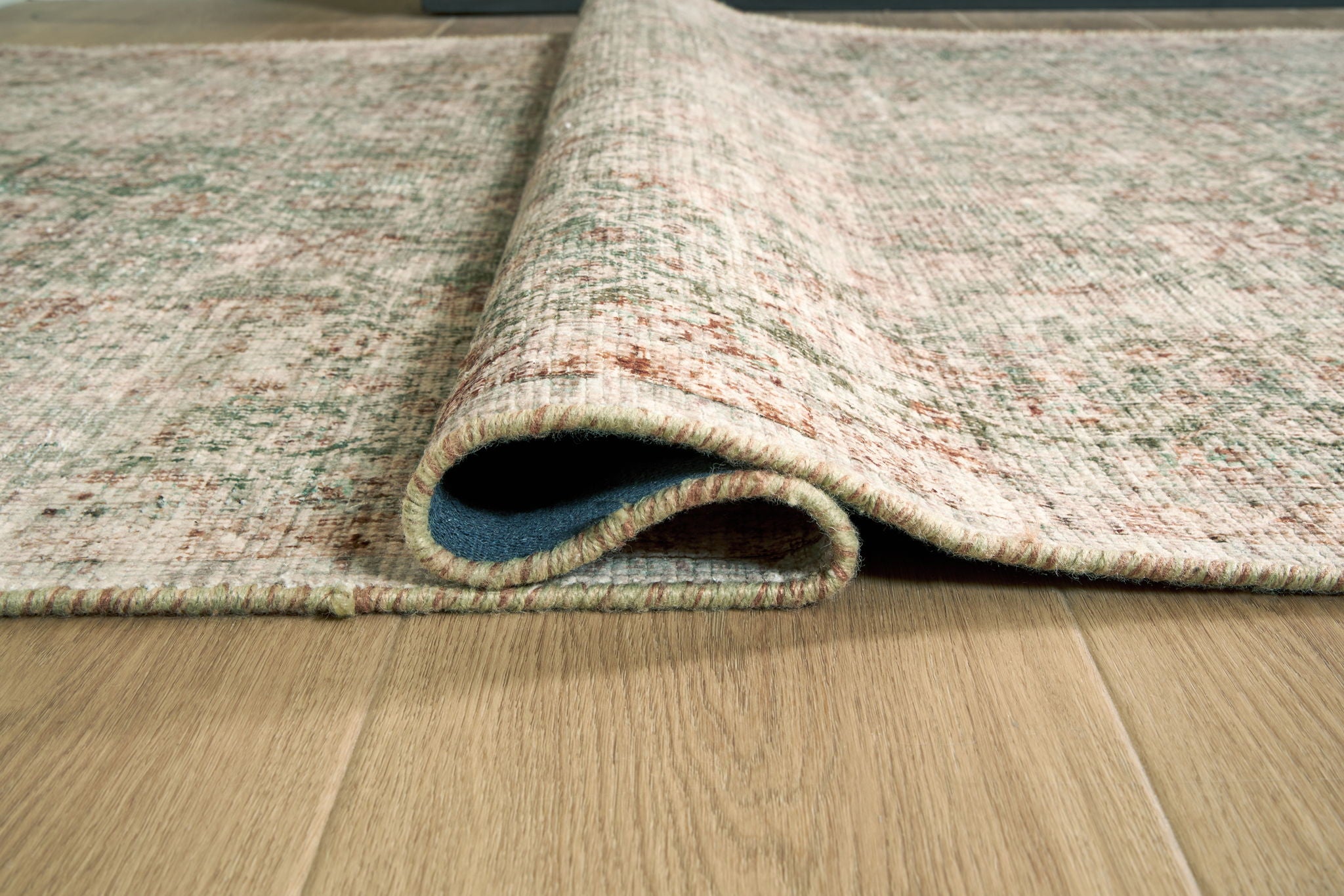 Rossbury rug rolled edge detail, light speckled fibers with short fringed trim
