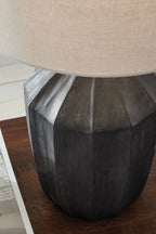 Black poly table lamp with beige shade, angled view of textured base