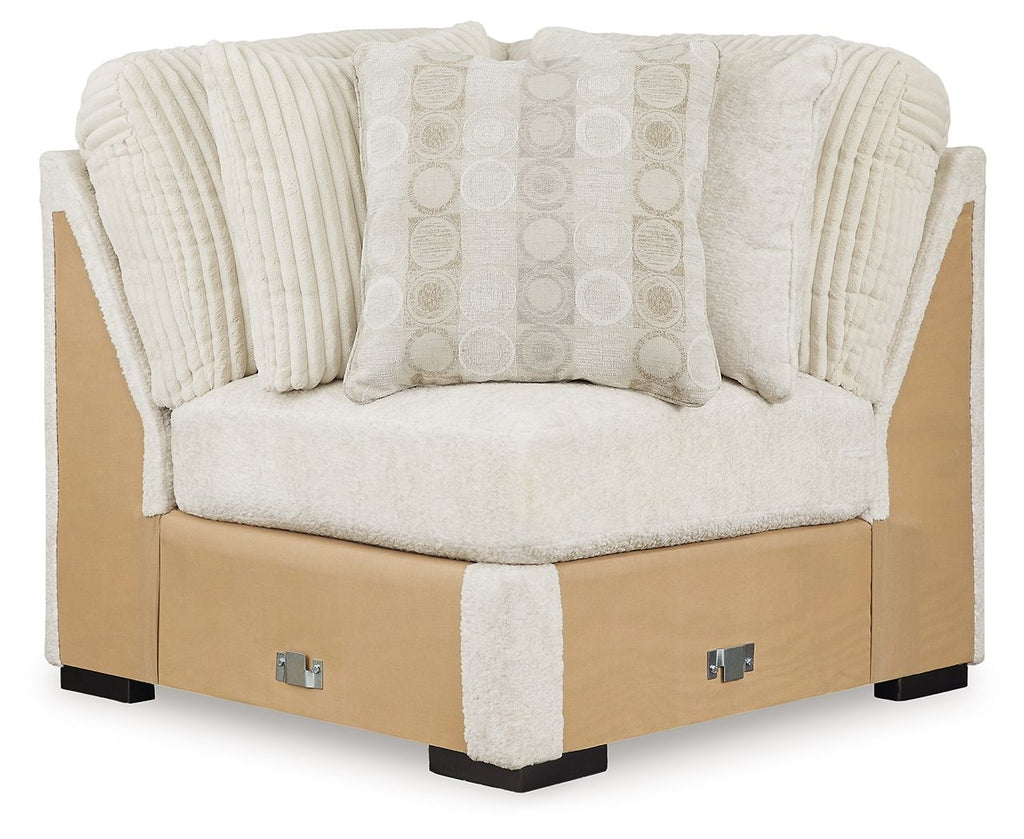 Ivory sectional wedge chair with textured arms and patterned back cushion