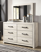 Light wood cabinet dresser with six drawers and black bar pulls, shown with decor