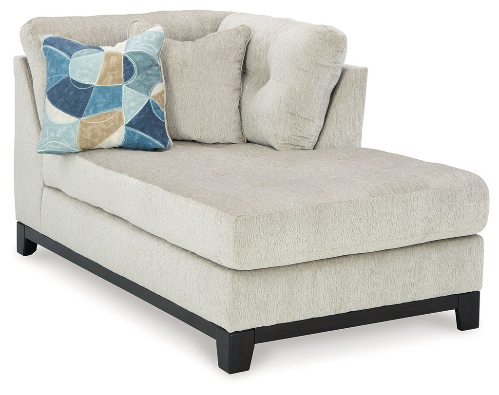 Stone corner chaise with sloped arms, tufted back cushions, and dark legs