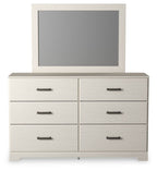 White dresser with mounted mirror and six drawers with black bar pulls