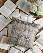 Decorative pillow with gray geometric design and small orange accents