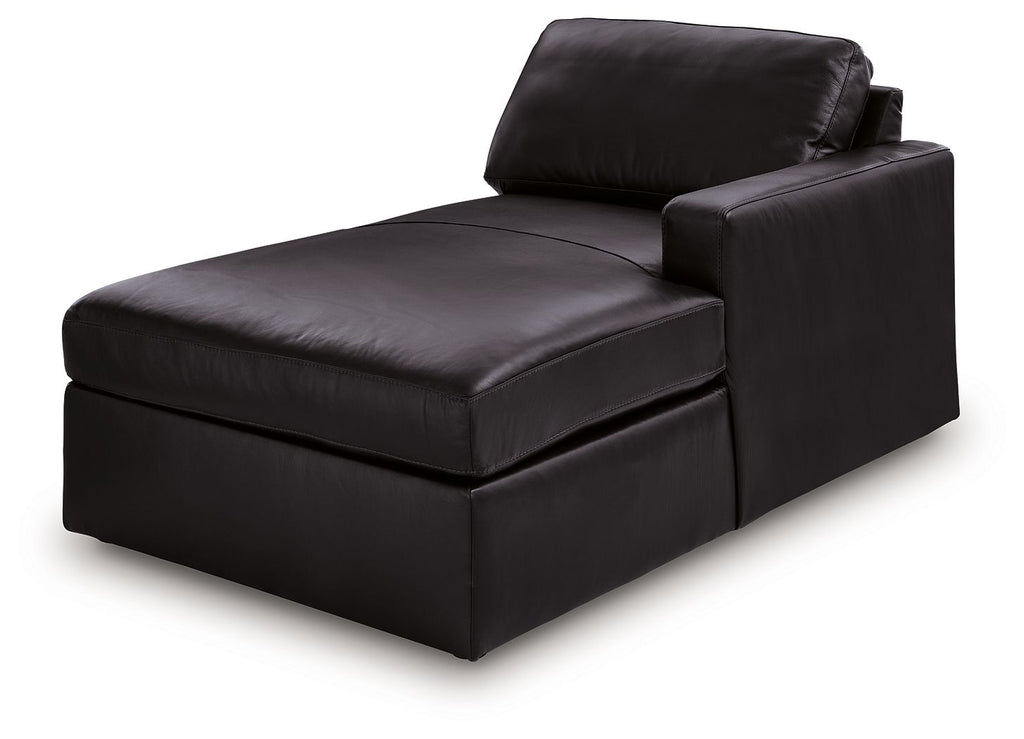 Black corner chaise with low armrest and wide seat, shown from side angle