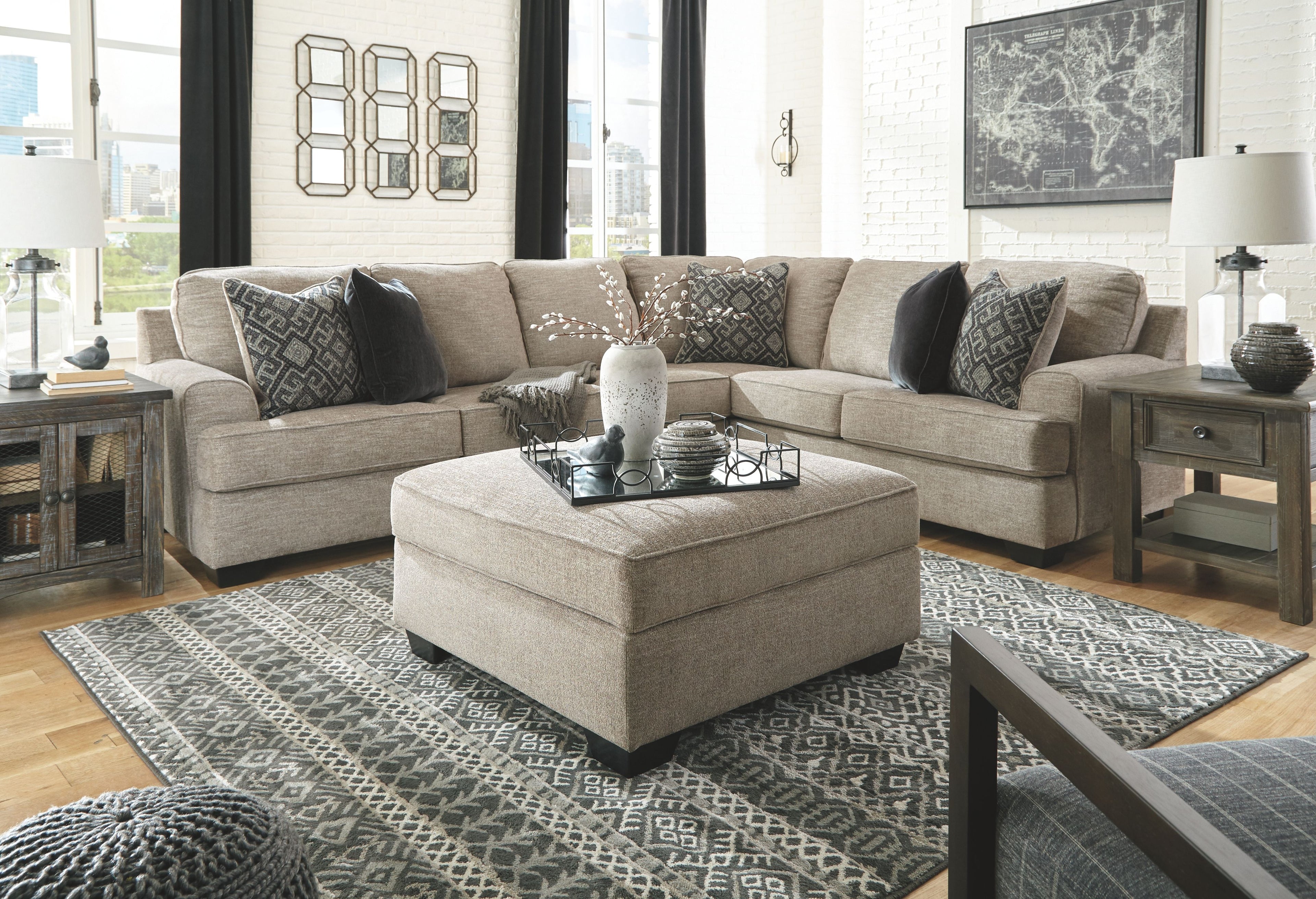 Beige sectional sofa set with center ottoman and patterned accent pillows